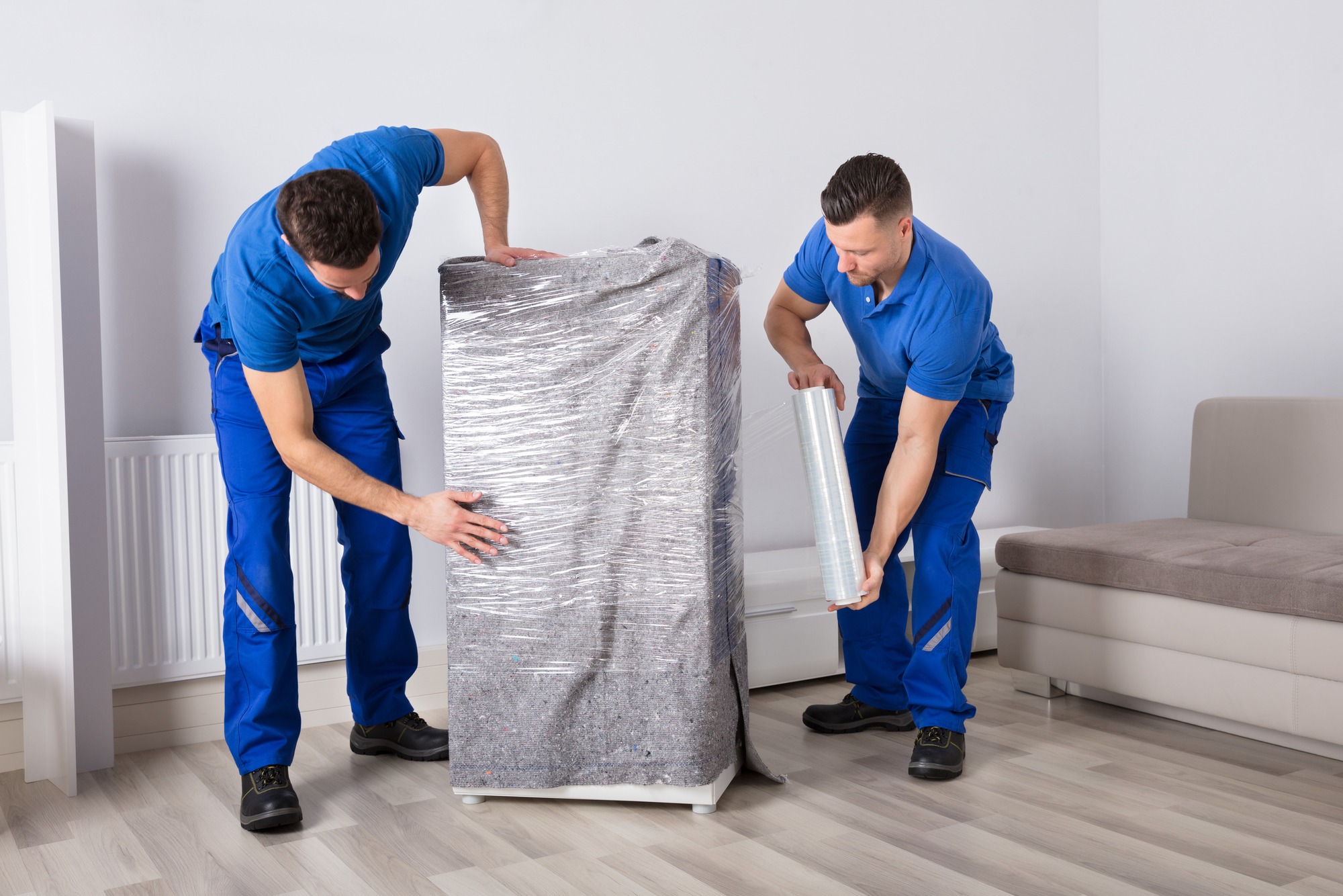 Two young male movers packing furniture