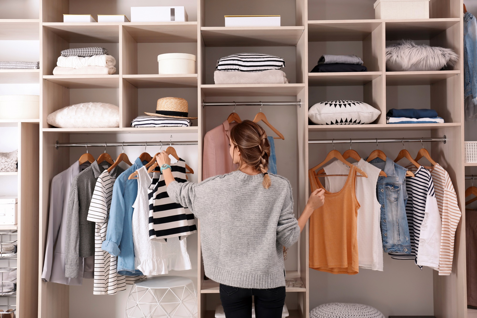 Woman organizing a large wardrobe closet